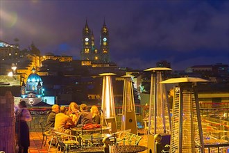 People on a terrace in front of the Basilica of the National Vow at night