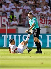 Referee Tobias Stieler helps Wataru Endo VfB Stuttgart