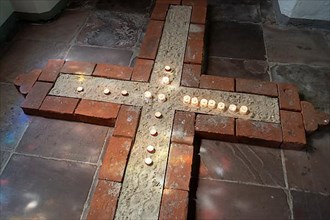 Cross with tea lights in a side aisle of the main Protestant church St. Johannis