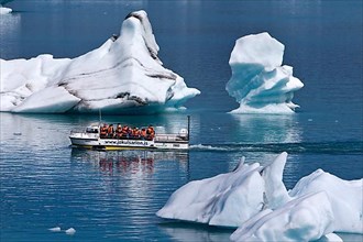 Tourists in an amphibious vehicle between icebergs