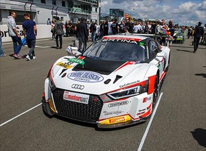 Audi R8 race car on grid in gridlane on start-finish straight of race track