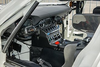 View inside cockpit of racing car Mercedes-AMG GT3 with bucket seat centre console electronic controls