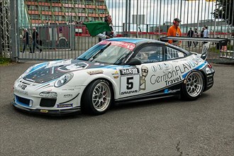 Race car Porsche 911 997 GT3 Cup sees green flag for exit on race track