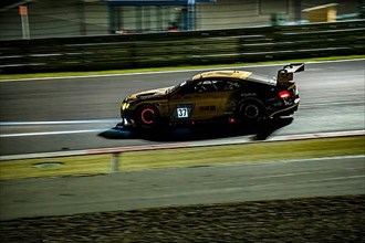 Bentley Continental GT3 racing car of racing driver Christian Menzel at night during 24-hour race 24h race car race on Grand Prix track of Nuerburgring race track with glowing brake discs