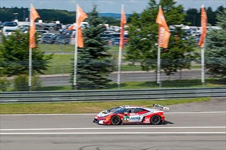 Racing car Lamborghini Huracan GT3 drives at high speed from exit of pit lane onto race track