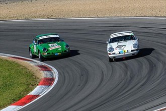 Two historic racing cars Porsche 911 overtaking side by side in curve during car race for classic cars youngtimer classic cars 24-hour race 24h race