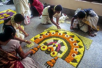 Women making floral decoration during Onam festival