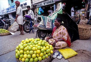 A woman selling mosambi fruit at City Market in Bengaluru Bangalore