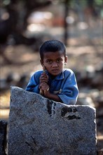 A boy resting on a stone slab