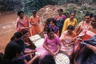 Kodava women making rice ball Kadamputtu during Huthri festival