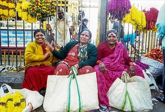 Three woman sitting in city market in Bengaluru Bangalore