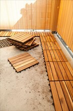 Laying of wooden patio tiles on balcony