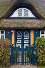 Ornate entrance door of the idyllic thatched-roof house in the village of Born