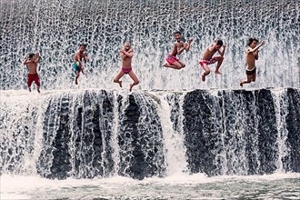Boys jumping into a waterfall and having fun