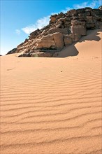 Dunes and rock formation in sand desert
