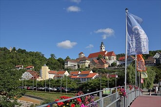Flags at the raftsman's footbridge and townscape with observation tower Schuetteturm