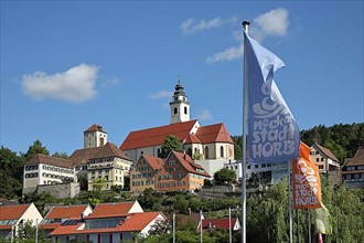 Flags at the rafter bridge and townscape with collegiate church and Schurkenturm in Horb am Neckar