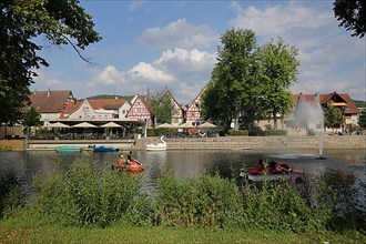 Pedal boats in the river Nagold with a view of the town of Nagold