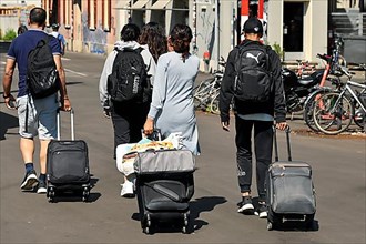 Travellers with rolling suitcases