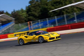 Racing car sports car Ferrari 488 Challenge speeds at full throttle at exit of corner hairpin La Source of racetrack