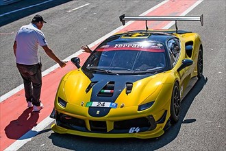 Racing car Sports car Ferrari 488 Challenge gets clearance from race marshal to exit pit lane onto circuit