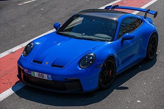 Blue sports car race car Porsche 911 992 GT3 in pit lane pit lane of race track