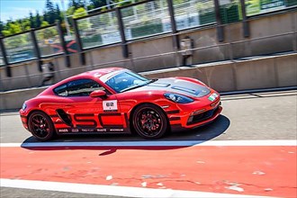 Sports car race car Porsche Cayman drives through pit lane Pit Lane of race track