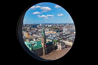 City view with the town hall through the porthole windows in the spire of the main church of St. Petri