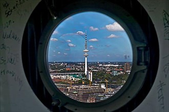 City view of the Heinrich Hertz Tower through the porthole windows in the spire of the main church of St. Petri
