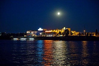 Atmospherically illuminated Stage Theater with the Elbe in the evening with full moon