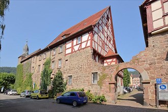 Historic town wall with blue hat and half-timbered house in Eberbach