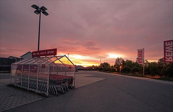 Shopping trolley in the Rewe car park at sunset