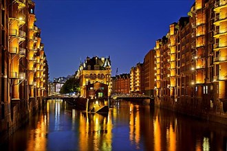 Illuminated moated castle in the Speicherstadt in the evening