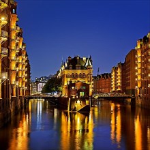 Illuminated moated castle in the Speicherstadt in the evening