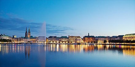 Inner Alster with Alsterfontaine and city skyline in the evening