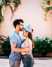 Boyfriend tenderly kissing his girlfriend forehead. Man kissing his girlfriend forehead outside. Cute couple embracing the boyfriend kisses the girl forehead. Portrait of beautiful couple in love