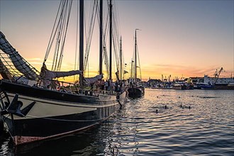 Sunset bathing among the sailing ships in the harbour