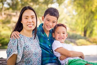 Outdoor portrait of biracial chinese and caucasian brothers and their mother