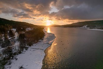 Winter landscape with lake at sunrise
