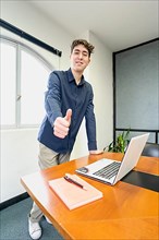 Young businessman standing at the head of the meeting table