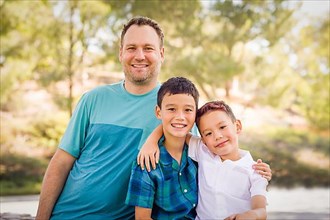Outdoor portrait of biracial chinese and caucasian brothers and their father