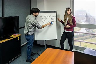 Employees making a presentation to their office colleagues in the meeting room