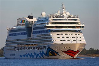 Cruise ship AIDA Sol leaving the port of Hamburg in the evening light on the Elbe
