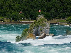 Viewing rock in the Rhine Falls with flag of Switzerland