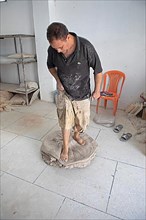 Moroccan potter at work: kneading the clay with his feet in the pottery workshop