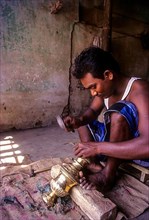An artisan working on brass lamp at Nachiyar Koil near Thanjavur Tanjore