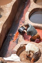 Workers dyeing leather