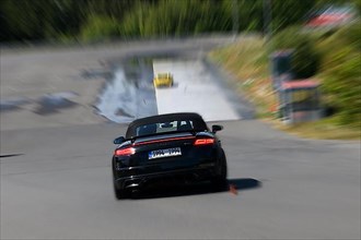 Dynamic photo with zoom effect of sports car Audi TT starts to retain control during slalom course at driving safety training