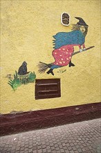 Mural on a house wall with flying witch on witches broom in Villingen