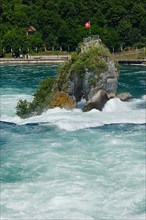 Viewing rock in the Rhine Falls with flag of Switzerland